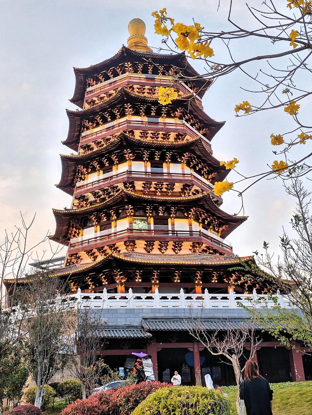 楼阁巍峨，耸入翠云，花影绰约，映耀金顶。信步园中幽径，此景令吾沉醉。
湖水漾起清