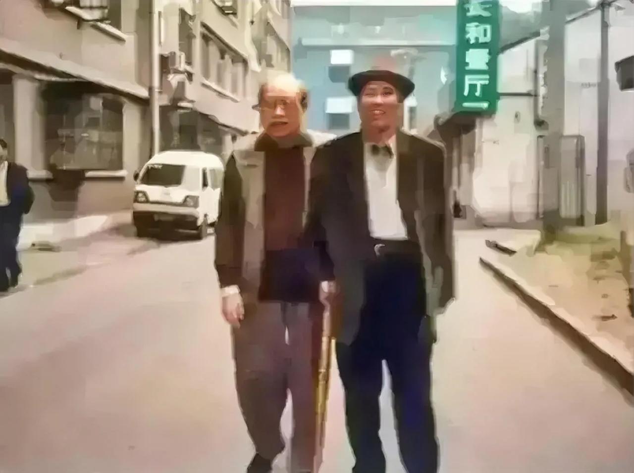 1990年的一天，北方某地的一条背街小巷里发生了这样一幕，两位老人在遛弯时不期而