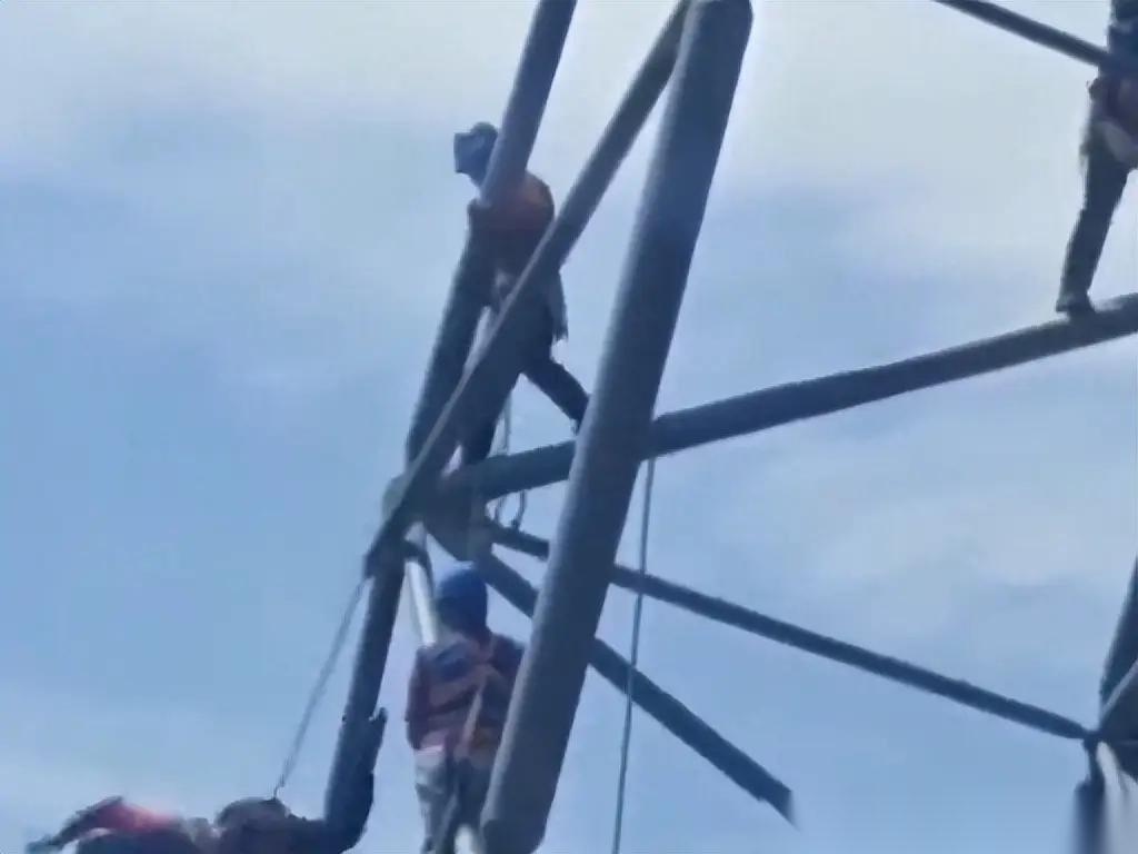 实在是太惊险了。两名工人正在几十米高的钢结构之上作业，不知道究竟碰上了啥解不开的
