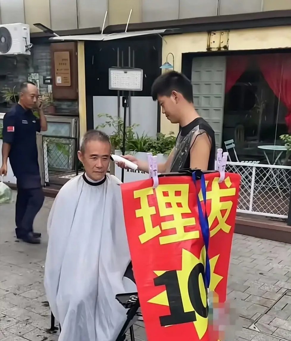 一位名人在街头理发的照片 