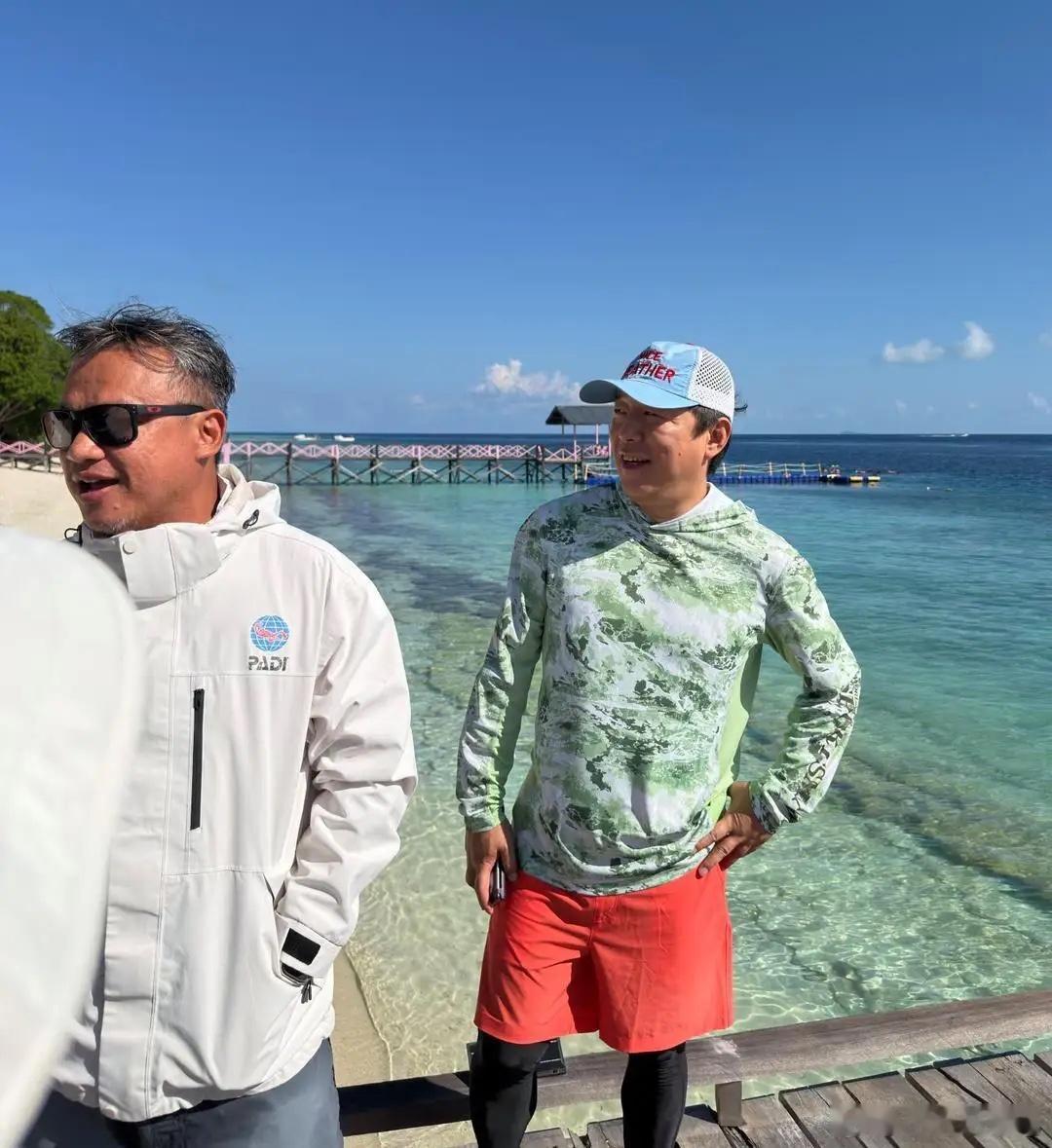 52岁黄渤在马来西亚坐船出海度假，他穿着一身泳装，戴着防晒帽，身材发福好多，脸变