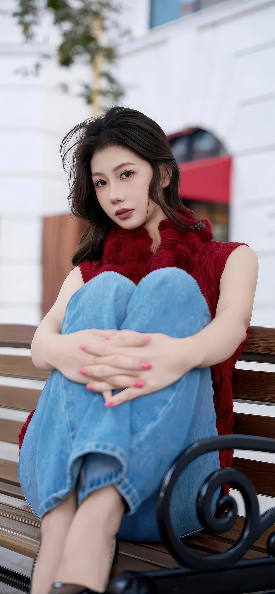 红衣少女坐长椅，秋日暖阳下，温柔似水。