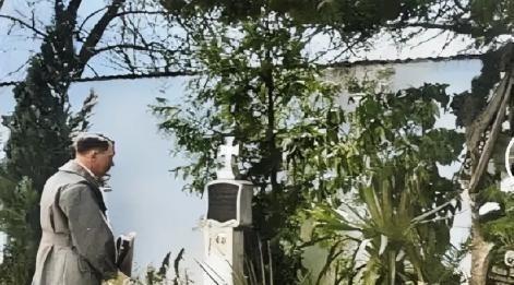 1938年3月13日，希特勒在吞并奥地利后，回到家乡，脱下帽子站在母亲坟前默哀，