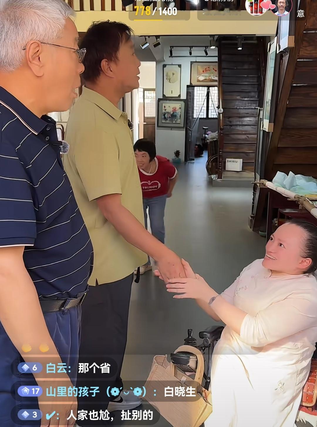 上海流浪大师沈巍参观湖南新化湘绣馆，慰问残疾人女老板。

被称为“行走的百科全书