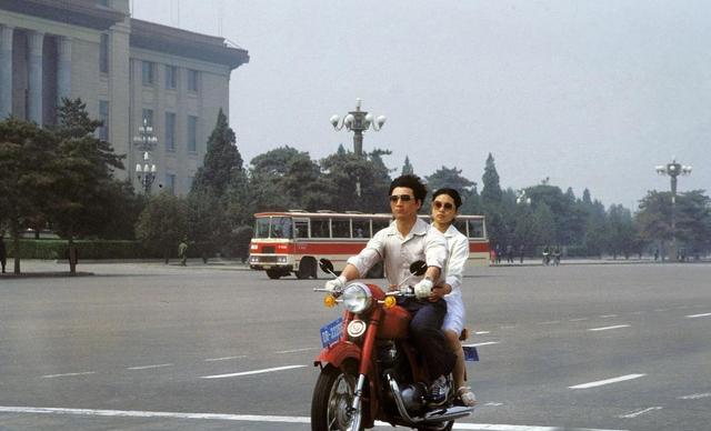 这张照片拍摄于1983年，照片上的年轻人带着女朋友骑车路过长安街，在当时有辆摩托