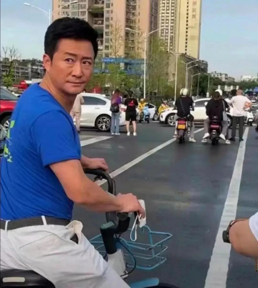 网友等红灯看到前面有位哥们，太像一个人，他用手机把它照下来，怎么看？怎么像吴京？