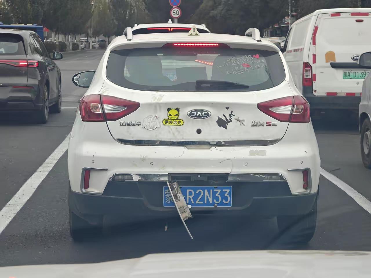 这样的情况算不算遮挡号牌？号牌上面的一个铁条，估计是时间长了，生锈导致一边彻底断