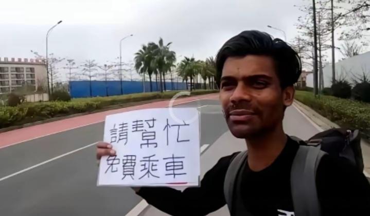 最近刷到一张照片在网上引发不少讨论：
一名外籍男子背着背包，在道路边举着手写纸牌