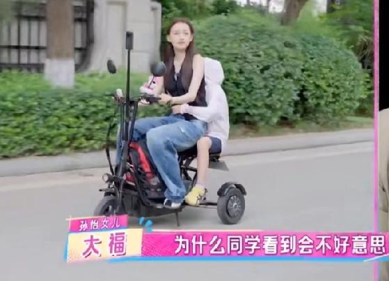 孙怡去接女儿放学，骑了一辆特别小的三轮车，后面只能坐一个小孩子的那种，看着就像一