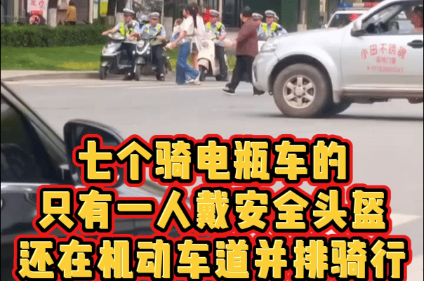 7个骑电瓶车等红绿灯的，只有一人戴了安全头盔，红色头盔的那位，强烈建议给帽子叔叔