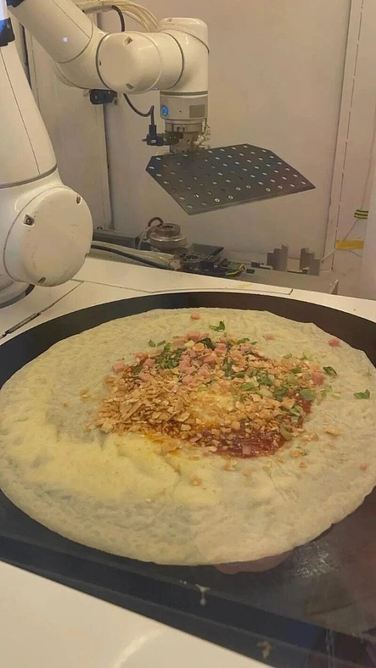 机器人摊煎饼果子科技遇上烟火气，全自动机器人精准复刻手工流程，摊面糊、打蛋、刷酱