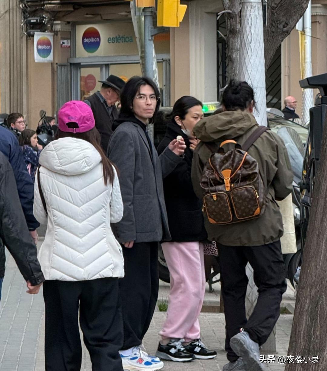 39岁萧敬腾和老婆林有慧在西班牙旅游被偶遇，他留着一头长发，脸部素颜，打扮有点一