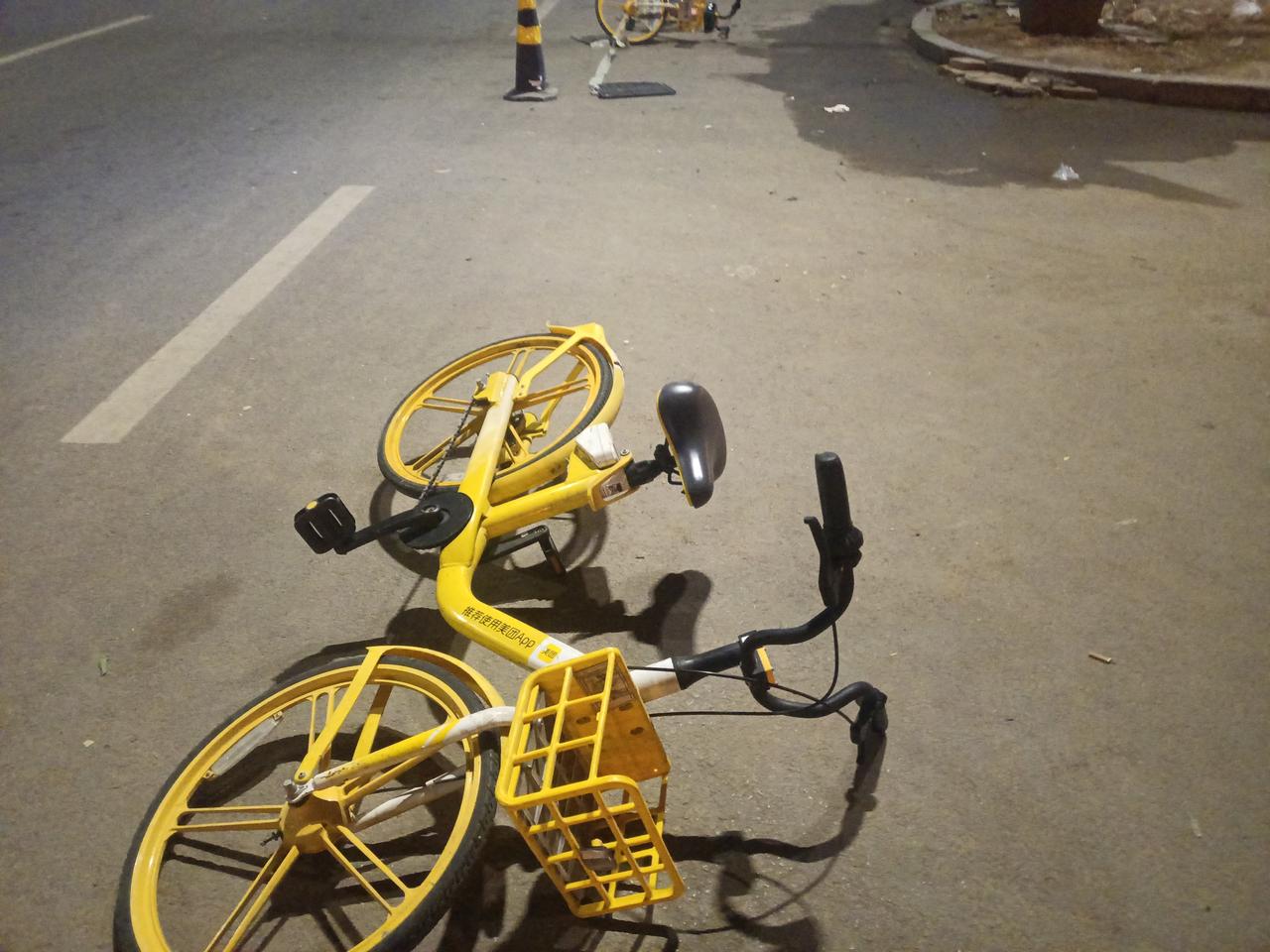 晚上遛弯，见路边横躺着几辆共享单车，刚想动手扶起来，老婆提醒我：你看看人家干啥用