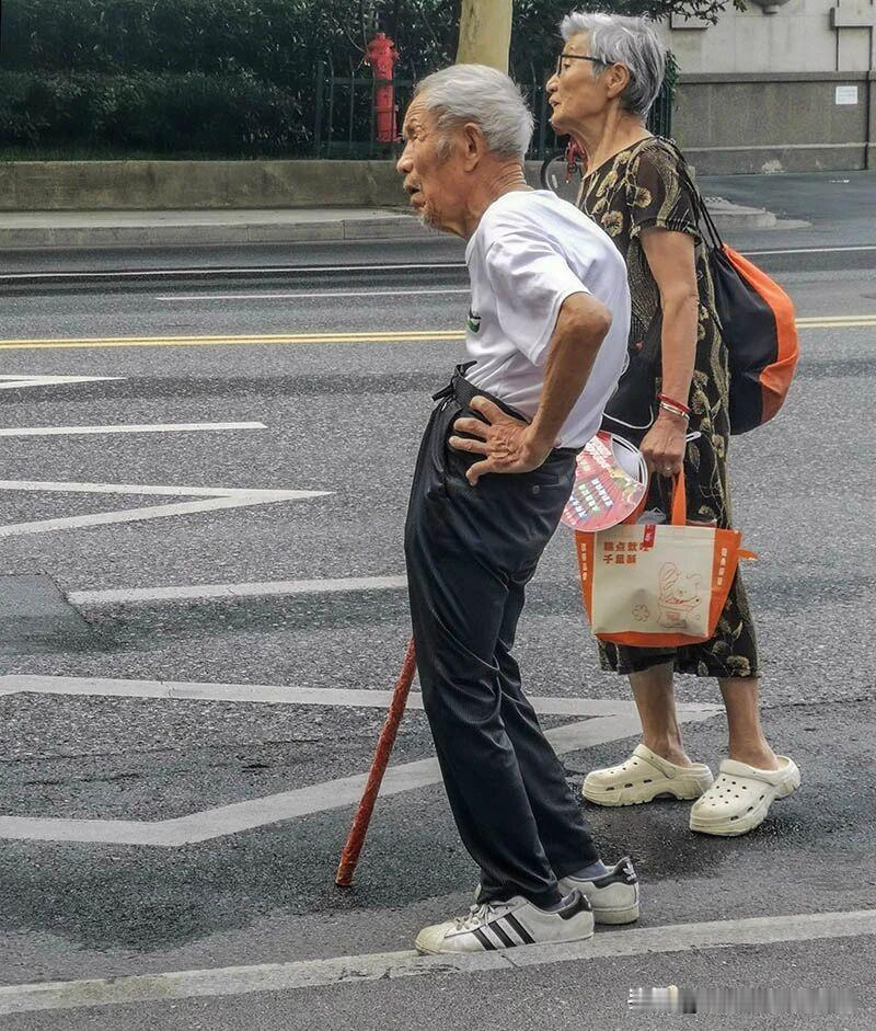 看看街头这一幕，
大爷的阿迪达斯，似大了两号。
大妈的卡洛驰，倒是挺时尚。
有人