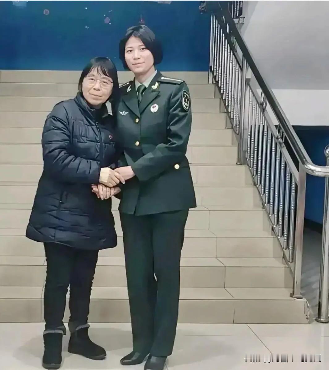 张桂梅老师与学生丁王英在学校楼梯口的一张合影。2025年，丁王英回母校看望恩师张