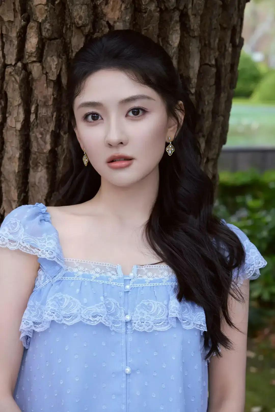 美女壁纸～梁洁，身着冰蓝色礼裙，裙摆垂坠的褶皱如林间溪流般灵动，抹胸处的银纹似晨