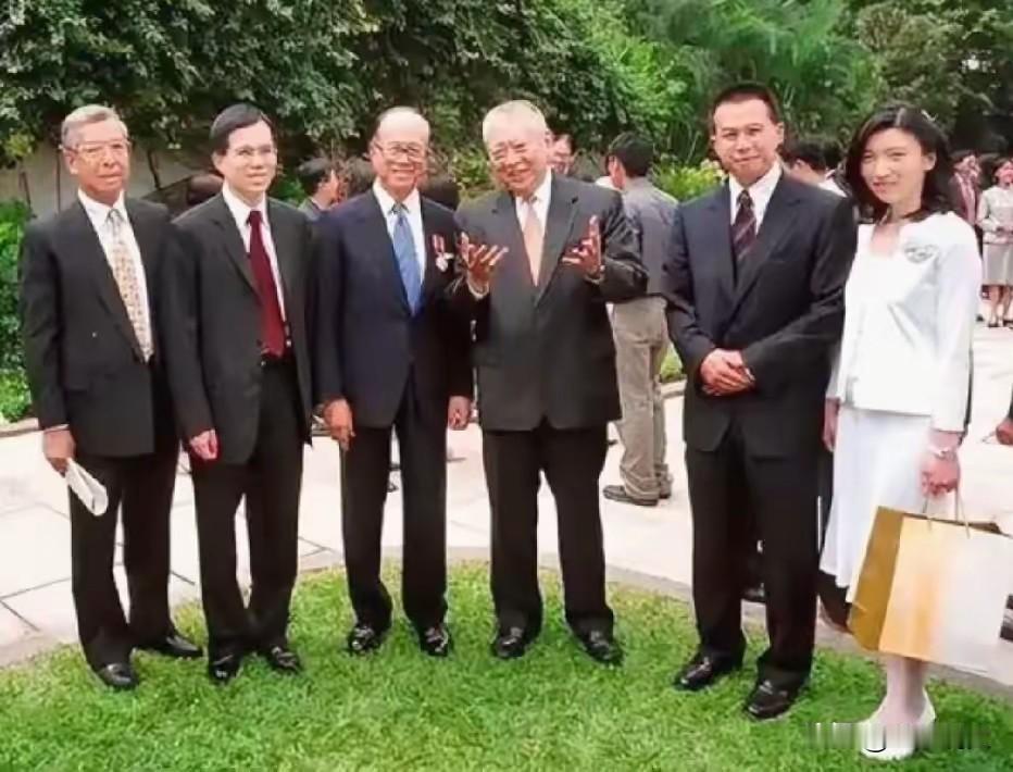 2001年，香港礼宾府。勋衔颁授典礼结束后，李嘉诚一家和董建华在草坪上留下一张合