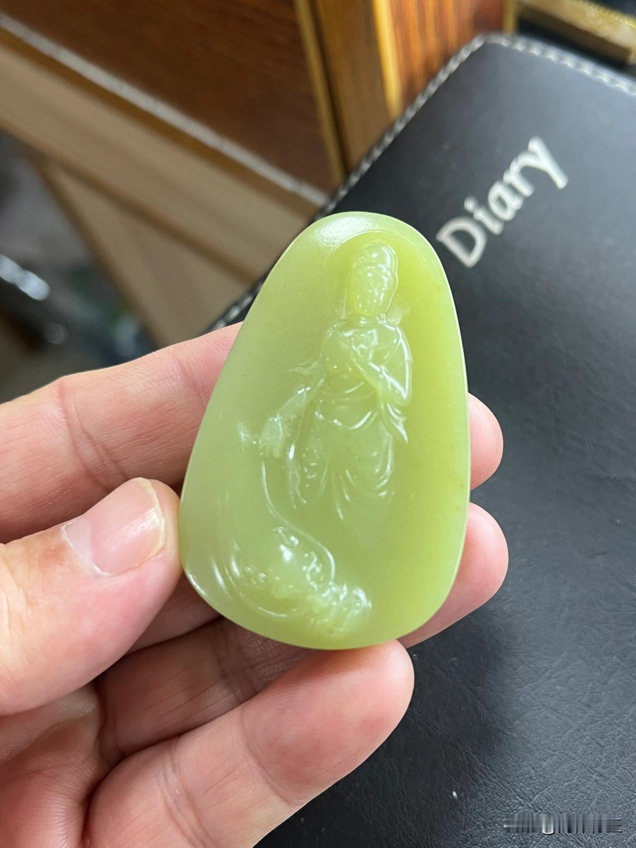 这块产地新疆若羌黄口观音玉牌，色泽温润淡黄，如春日初绽的花蕊般柔和。玉质细腻，触