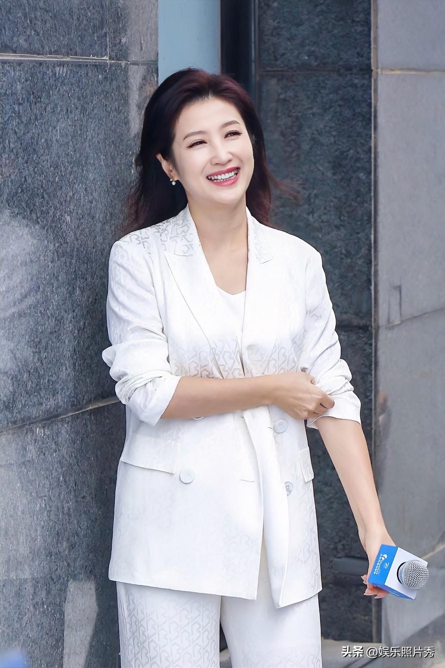 她颜值不高，但是笑起来那种知性优雅真是赶得上周涛！

她一身白色套装，朴素简单，