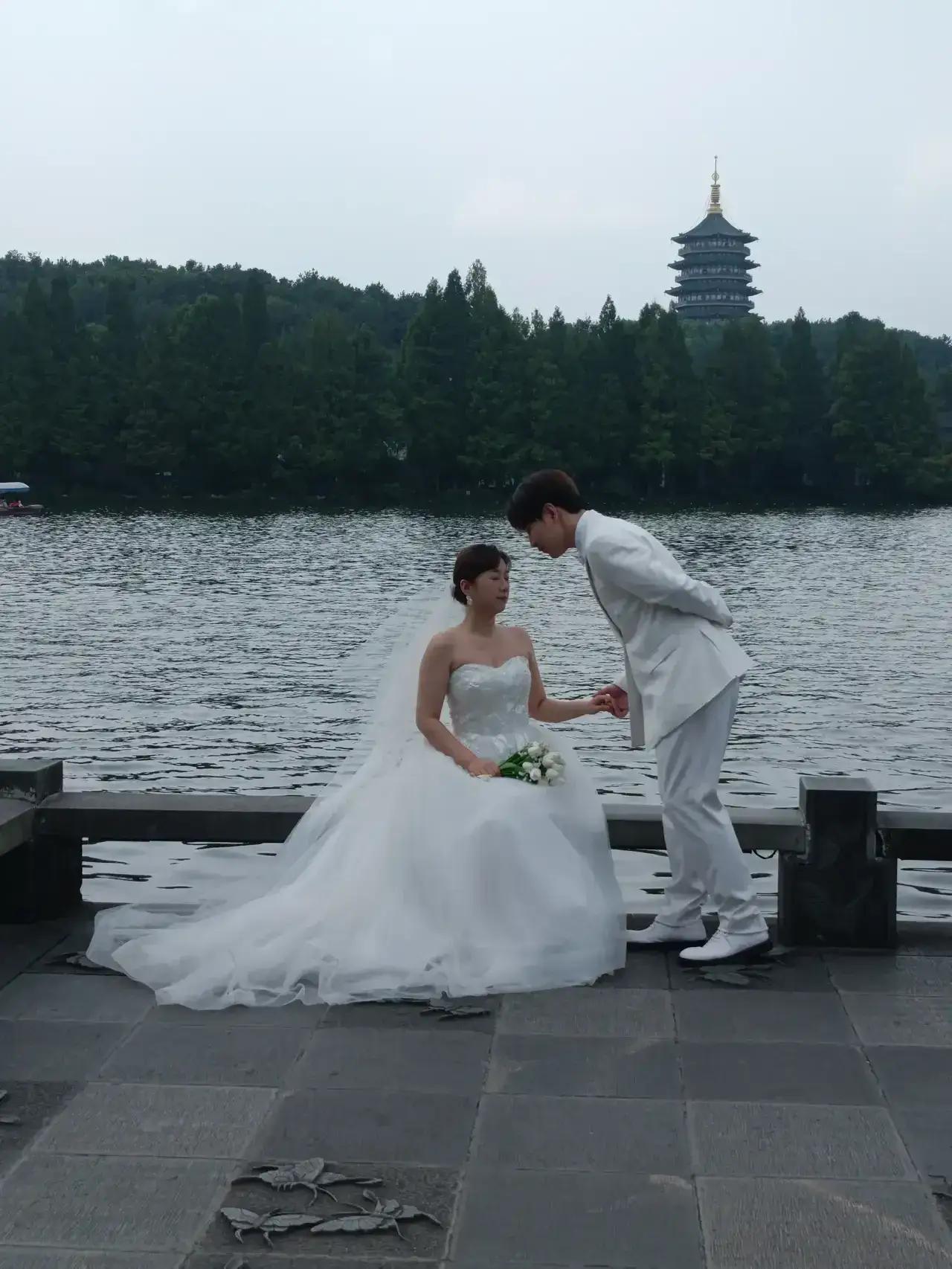 爱情总是那么的美好，新人们拍摄婚纱照脸上都是藏不住的欢欣！杭州西湖雷峰塔前的长桥