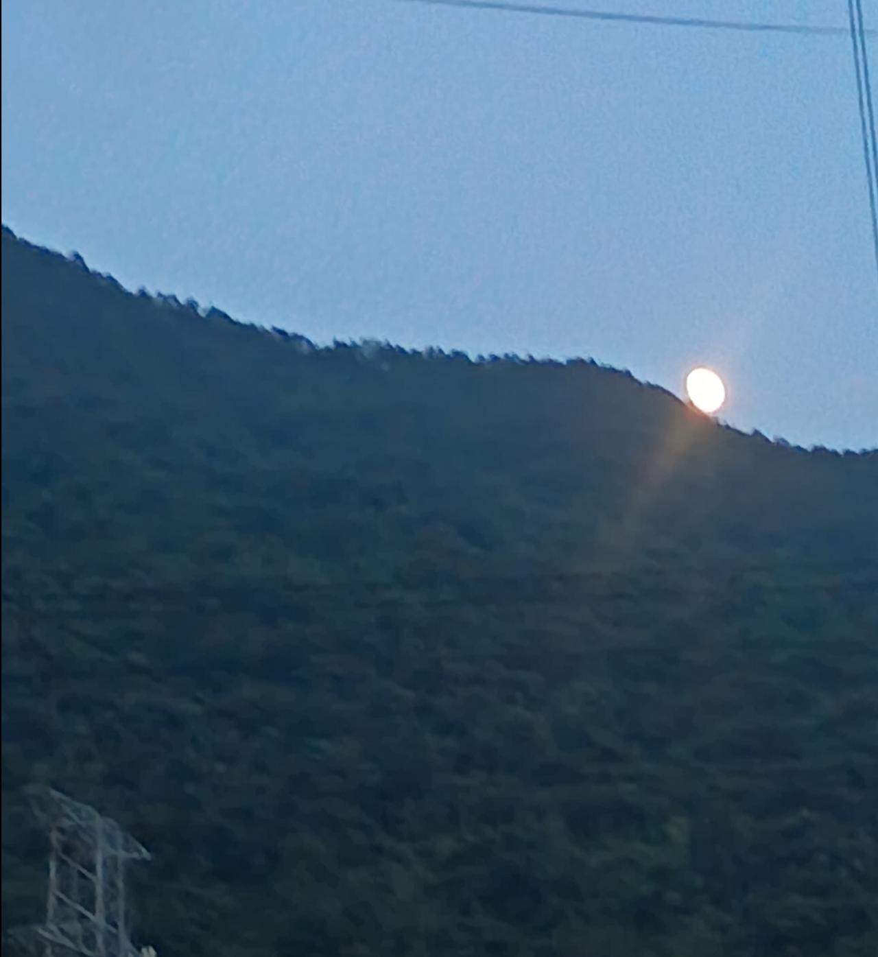山尖月
在烈日炙烤一天的 街边上，乘凉的人光着膀子趁着夜色慢步行走在马路上。这时
