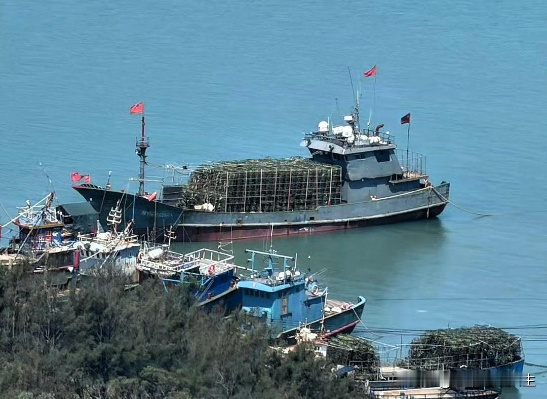 好家伙，画面里咱们这条装满了蟹笼的灰色涂装渔船，这怎么越看越有点儿不太“正经”啊