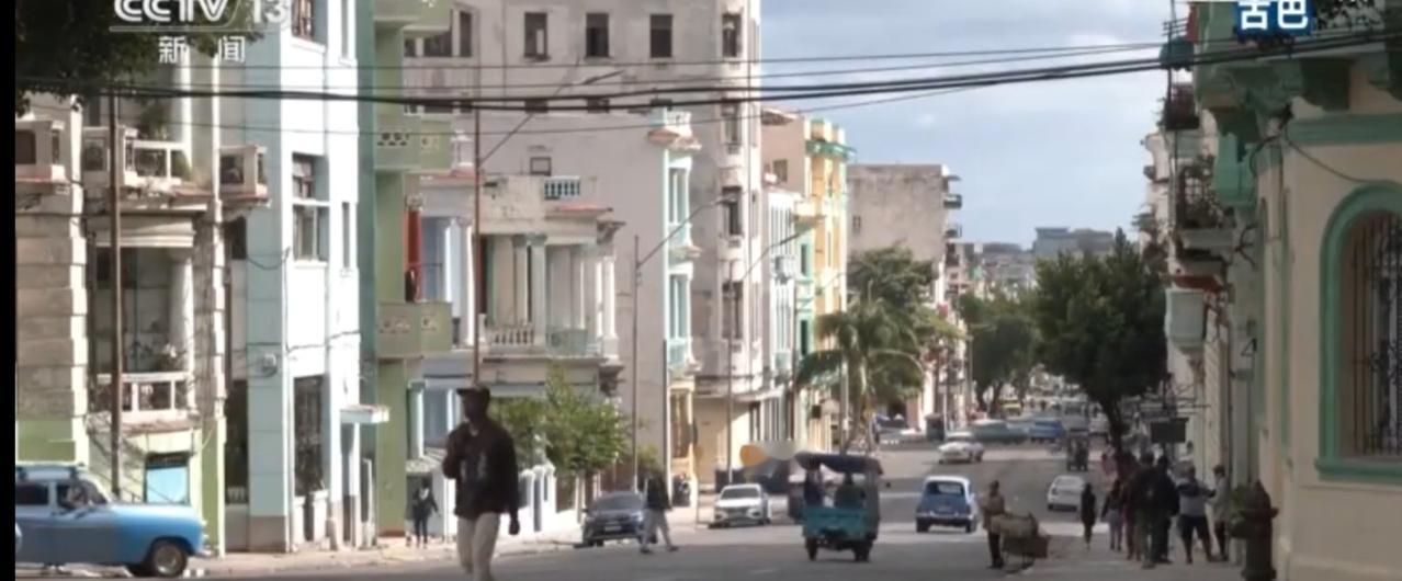 在古巴的街头，色彩明快的殖民风格建筑与复古的老爷车相映成趣，行人步履从容，勾勒出