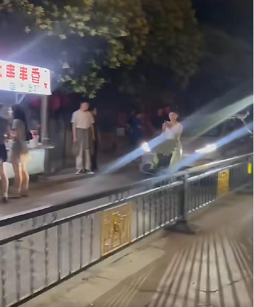 5月30日晚间，河南开封。一处单行车道上，一名女子推着婴儿车径直站在道路中央，直