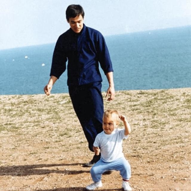 这两张照片记录的是一代武术宗师李小龙与他的长子李国豪在海边训练的珍贵瞬间。这组照