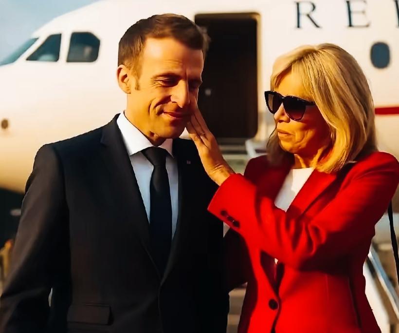 布丽吉特用手轻抚马克龙的脸，是不是很甜蜜啊？
马克龙以微笑回应，应该感觉很幸福吧