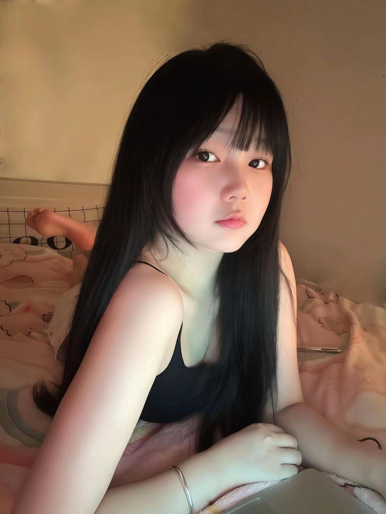 这女孩躺在床上，看着镜头。