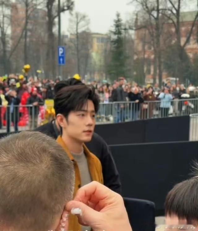 被人群簇拥的肖战，人群中，闪光灯最多的地方就是肖战
秀场灯光很暗，但有肖战的地方