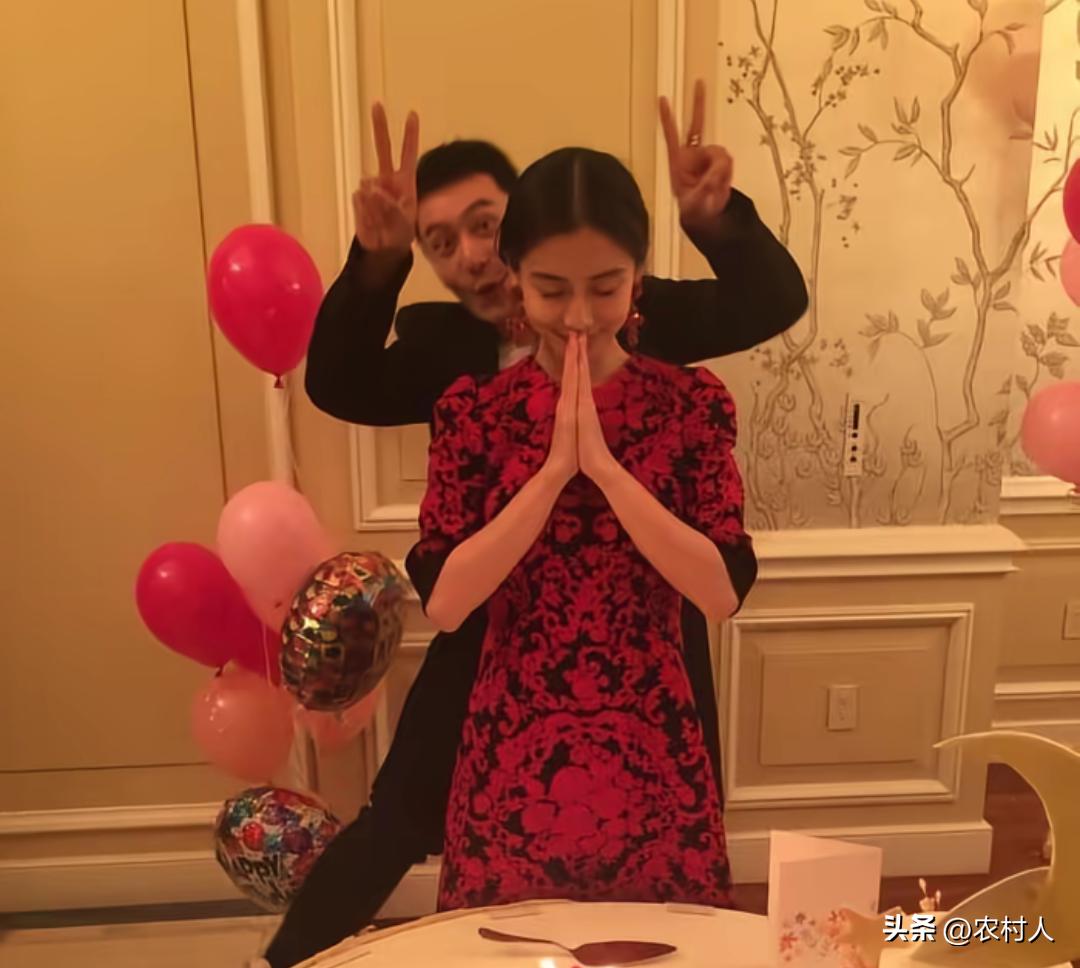 黄晓明和杨颖早年恩爱时期的经典生日合照，杨颖身着红黑花纹连衣裙。双手合十闭眼对着