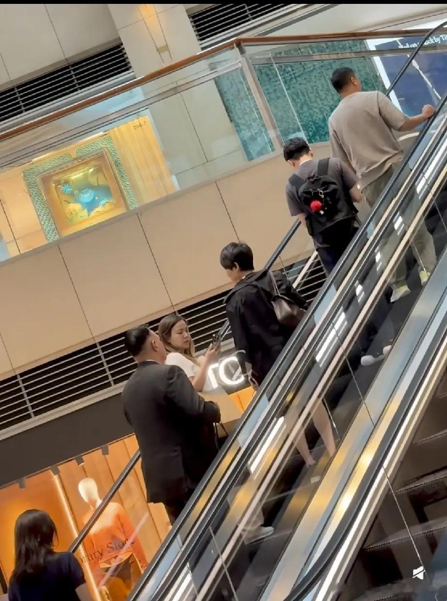 梁安琪带四名保镖现身香港置地广场，她还挺高调的，打扮也挺时尚的，从背后看不像老太