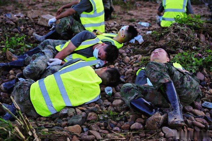【战士们连夜清淤后席地而睡】7月10日零时许，空军官兵星夜驰援受灾严重的横州市校