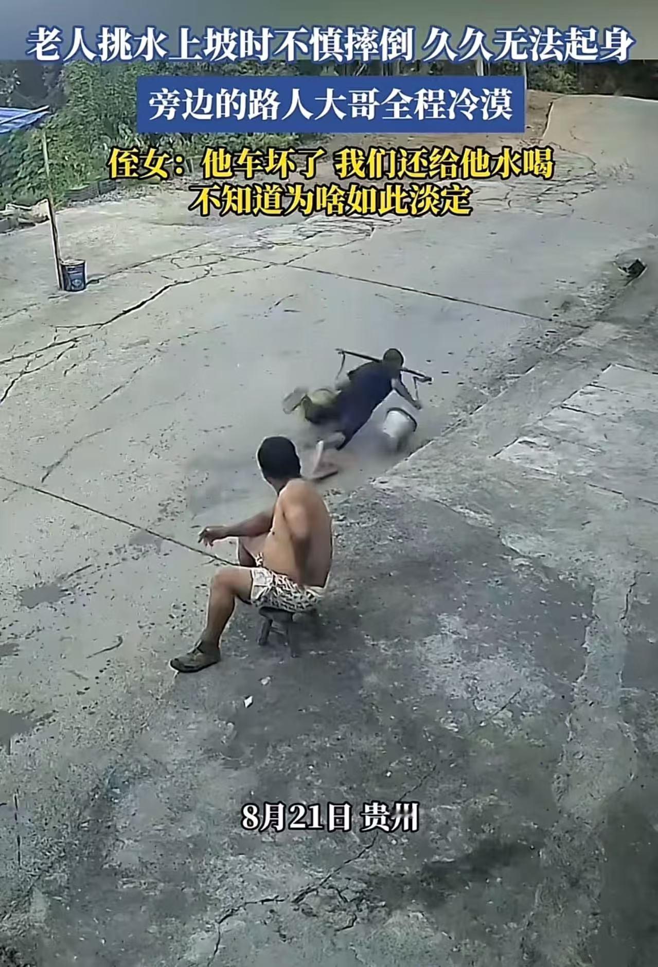 老人挑水上坡不慎摔倒，久久不能起身，旁边一个路人大哥全程目睹，却一动不动！老人侄