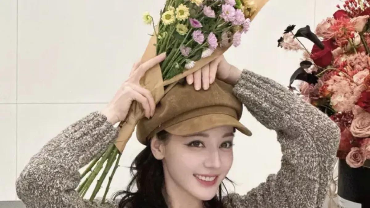 迪丽热巴以一幅清新脱俗的画卷，点亮了众人的目光。她手捧着绚烂的鲜花，仿佛春日里最