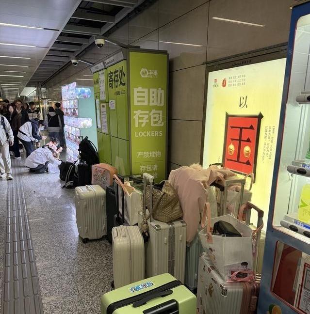 近日，江苏南京站，大批大学生游客嫌寄存处收费太贵，不料有人灵光一闪竟将行李箱摆放