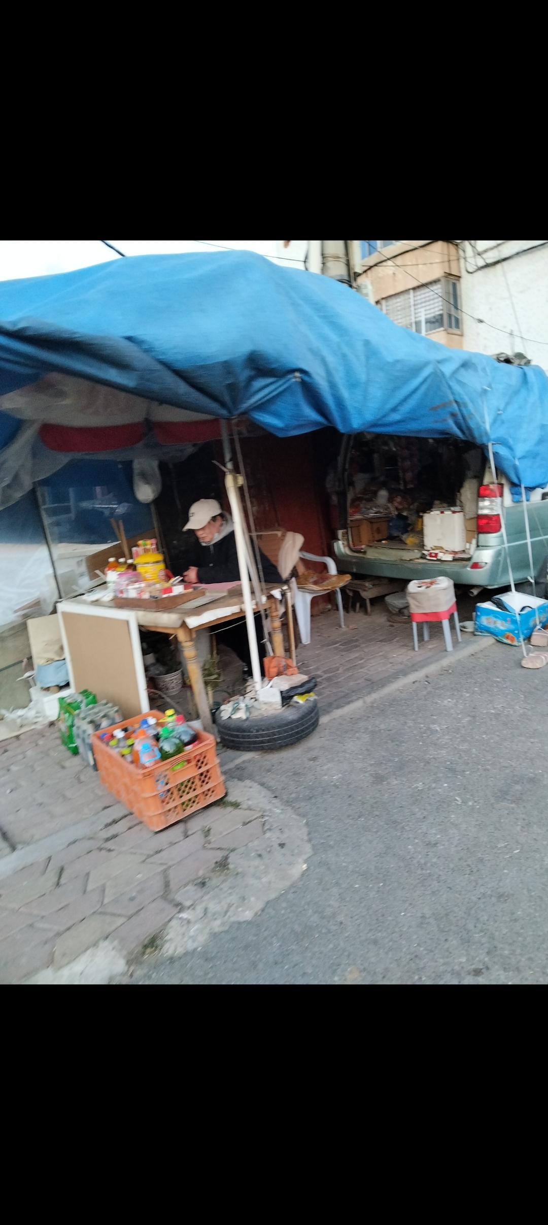 一辆老面包停在街上，再搭一个大帐篷，一个旧桌子加板凳，就是一个小百货商店。火腿肠