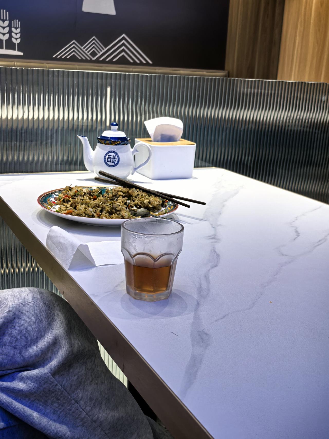 她一边玩手机一边吃饭，待我吃完饭她还坐在那里。大概有我10分钟左右，她不吃也不喝