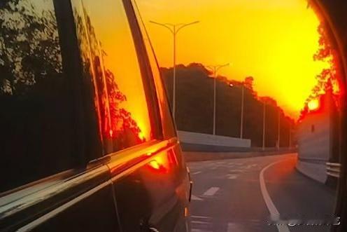 天南地北大拜年后视镜框住橘色落日，车影浸在熔金里，路肩的风裹着暖光晃过。树影与车