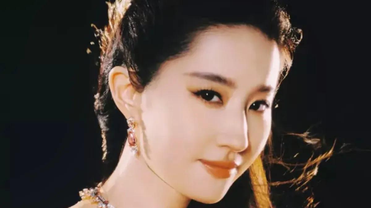 刘亦菲身着一袭温柔的杏粉色拖尾长裙，犹如从梦幻中走出的仙子，气质出众，令人倾心。