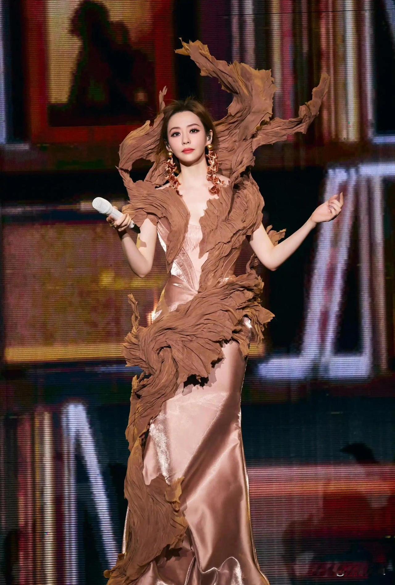 舞台上的张靓颖表现力真的太绝了！

一身浅香槟色修身缎面长裙勾勒身姿，外面叠加层