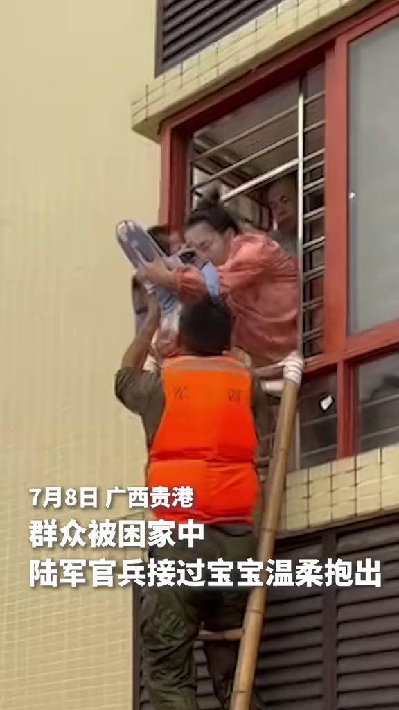 窗内递出宝宝，梯子上的官兵稳稳接住。广西贵港，群众被困家中，陆军官兵架梯接应、转