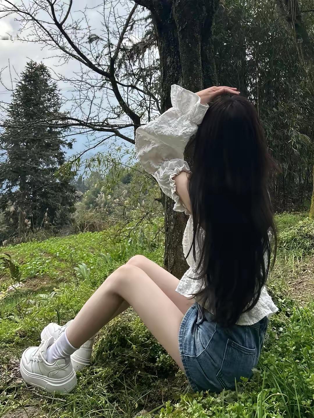 一个人坐在草地上，享受大自然。