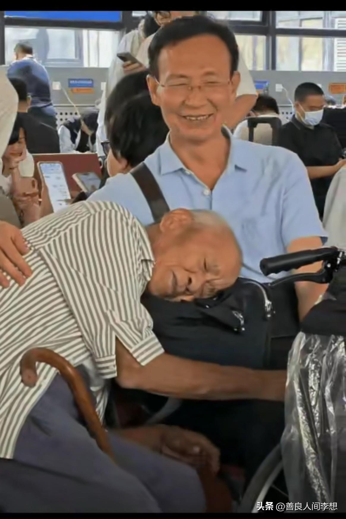 老父亲趴在儿子的腿上，儿子一手放在父亲的后背上，像不像我们小时候趴在爸爸妈妈怀里