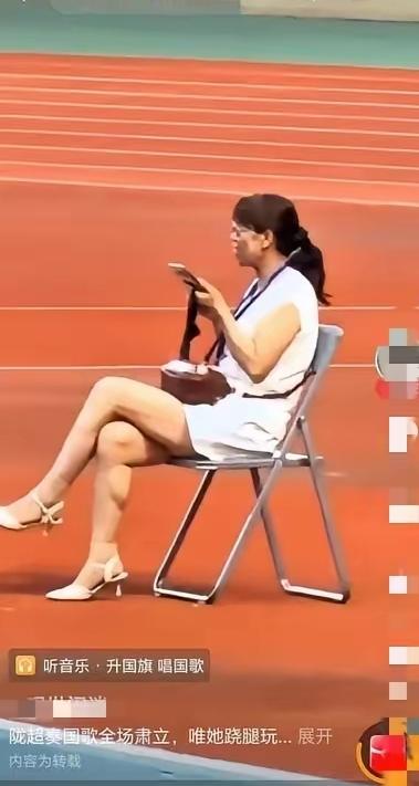 陇超平凉赛区升旗仪式，全场观众起立致敬，唯独一名女子翘腿玩手机，丝毫没有敬畏之心