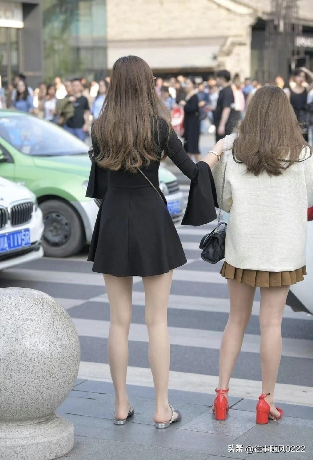 都市街头时尚姐妹，手牵手漫步在繁华街头