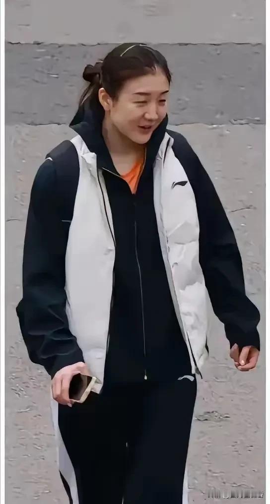 陈梦终于被网友拍到在去总局训练的路上，一身黑色的运动服配米色的羽绒马甲，由于是北