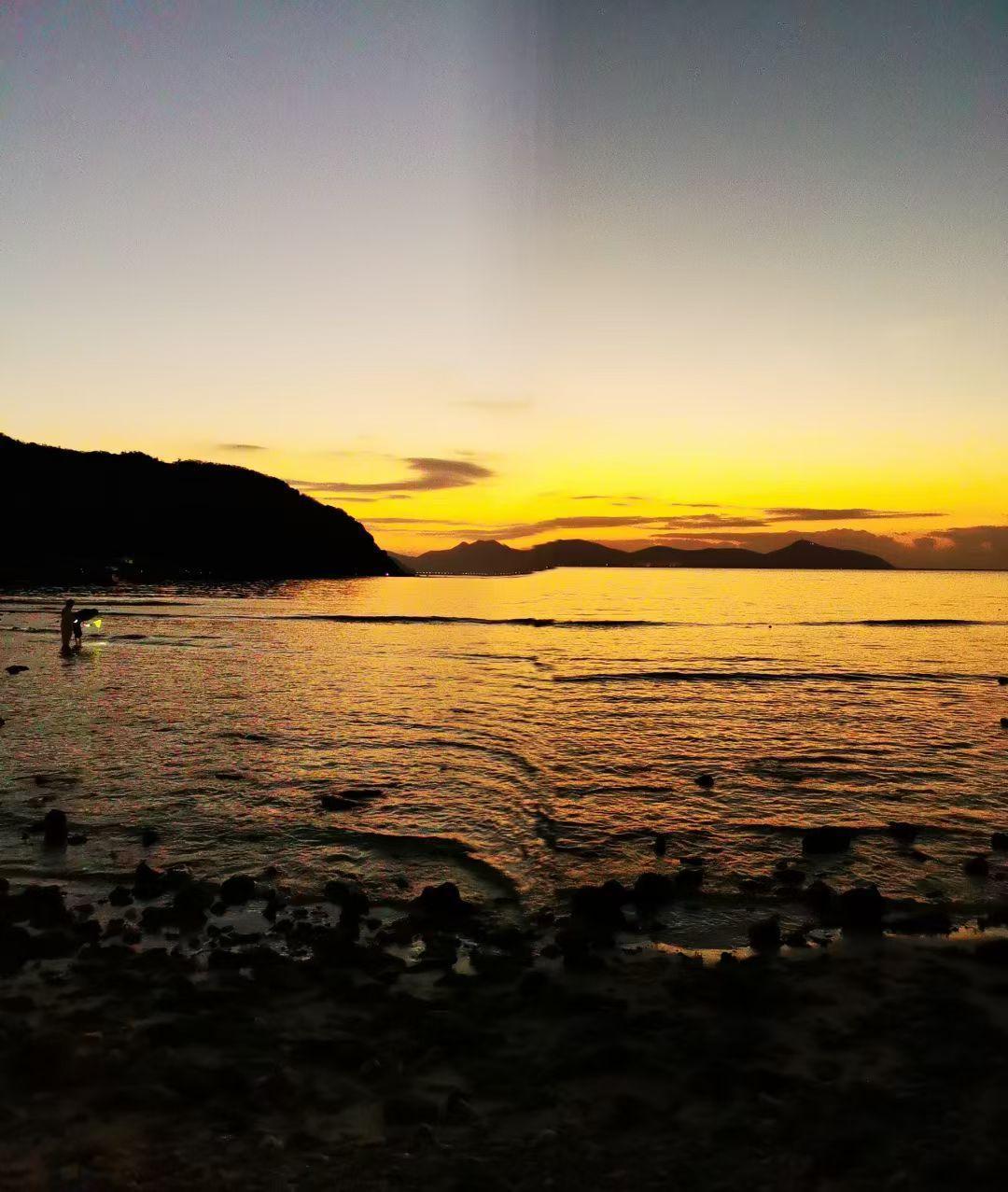 海把落日熔成的金箔，轻轻铺在浪尖上；人影提着微光，在暮色里打捞一整个黄昏的温柔。